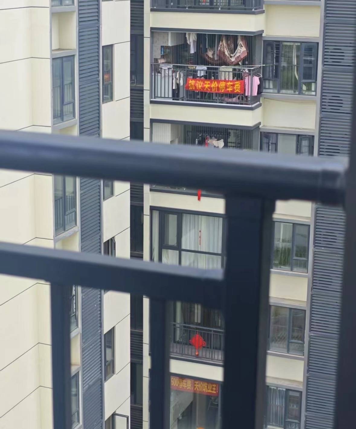 广州一小区有住户阳台挂横幅抗议“天价”停车费，回应：每月450元，属正常价格